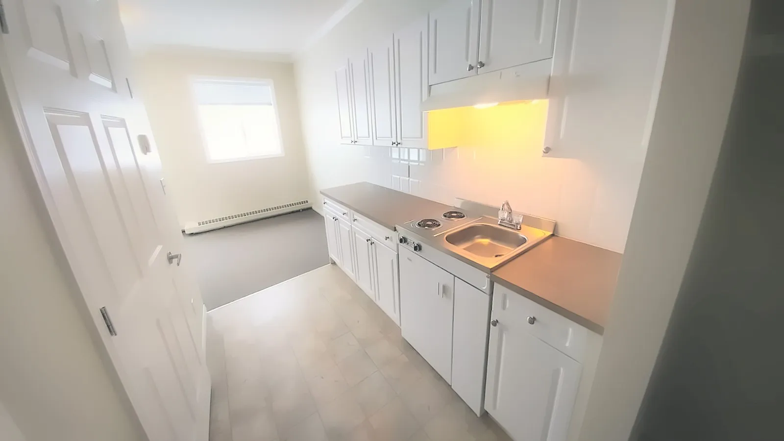 Suite kitchenette with white cabinets, a two-burner range and a sink
